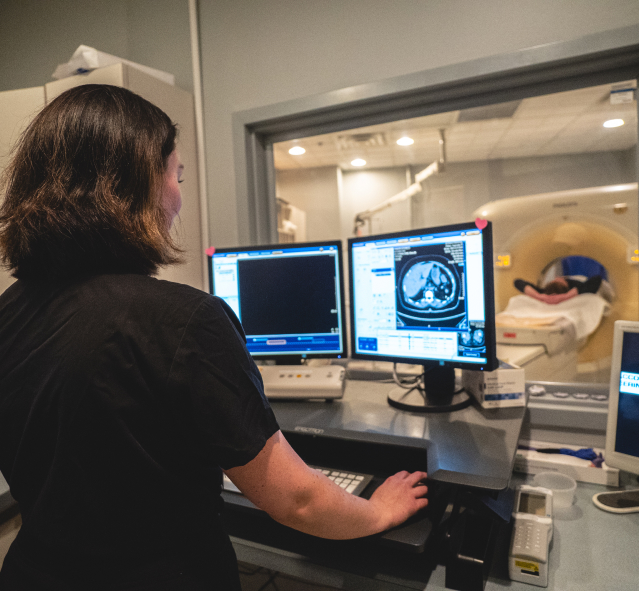 tech administering a CT scan